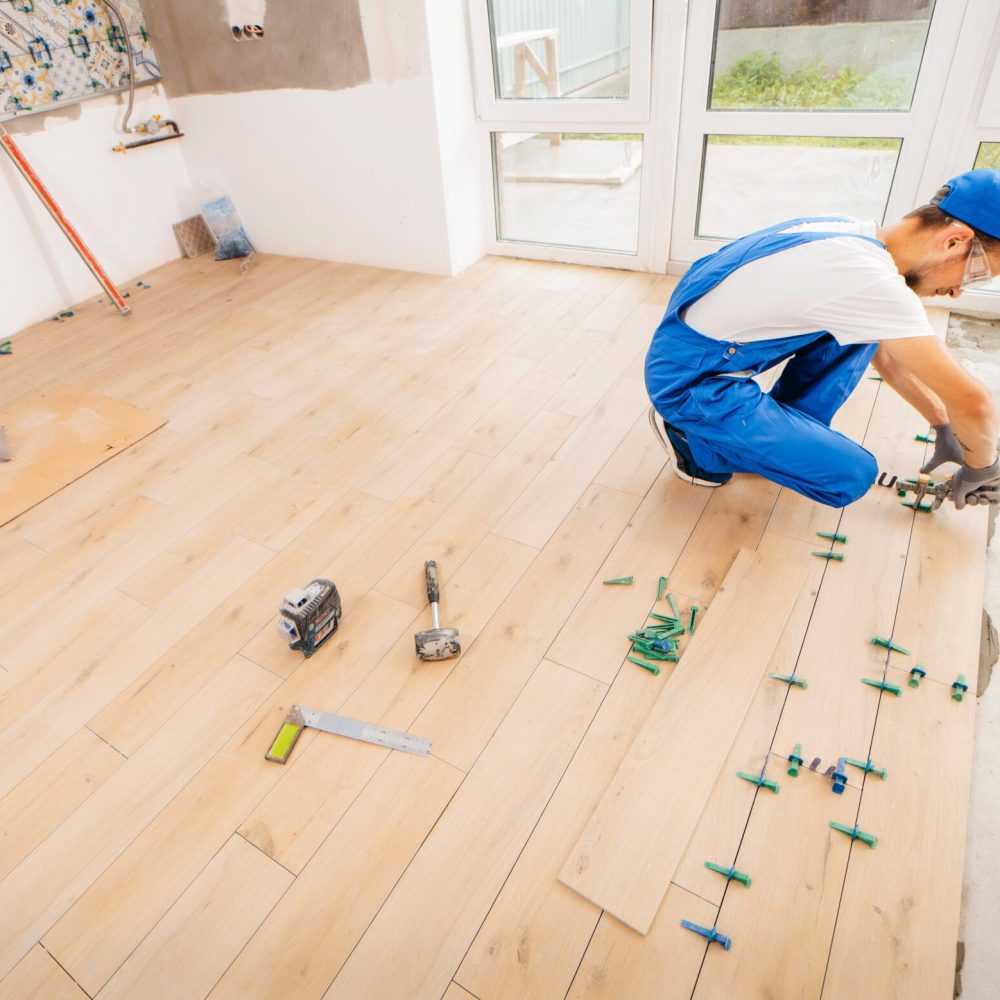 adult-repairman-special-uniform-laying-tiles-with-tile-leveling-system-floor